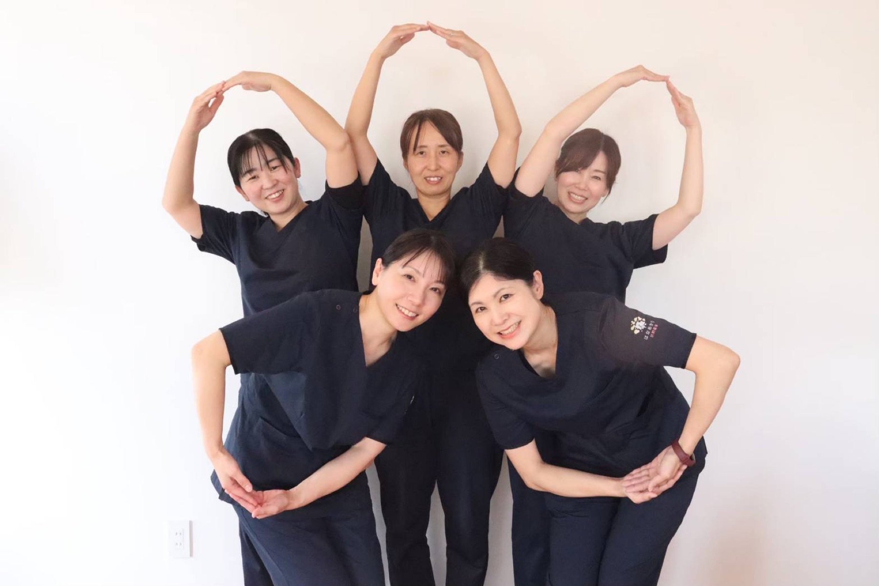腕で花のかたちを作るはなあかりのスタッフたち